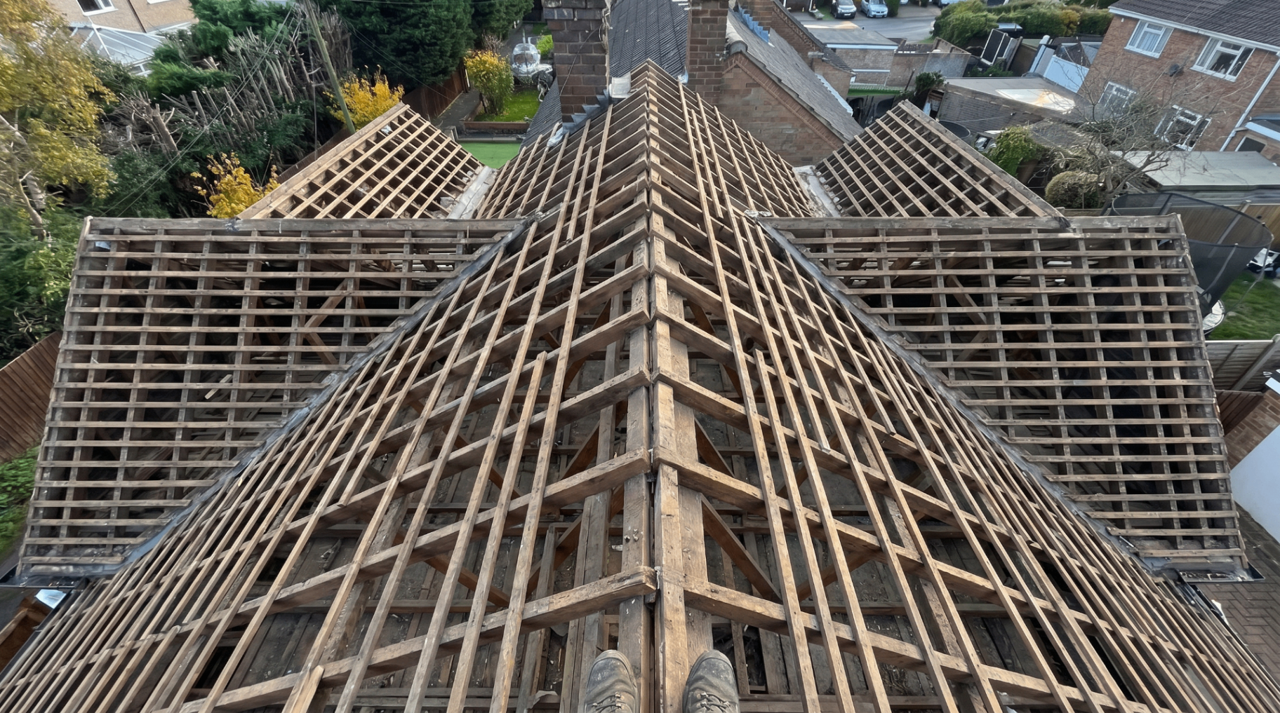 Before — stripped roof showing bare timber rafters and battens