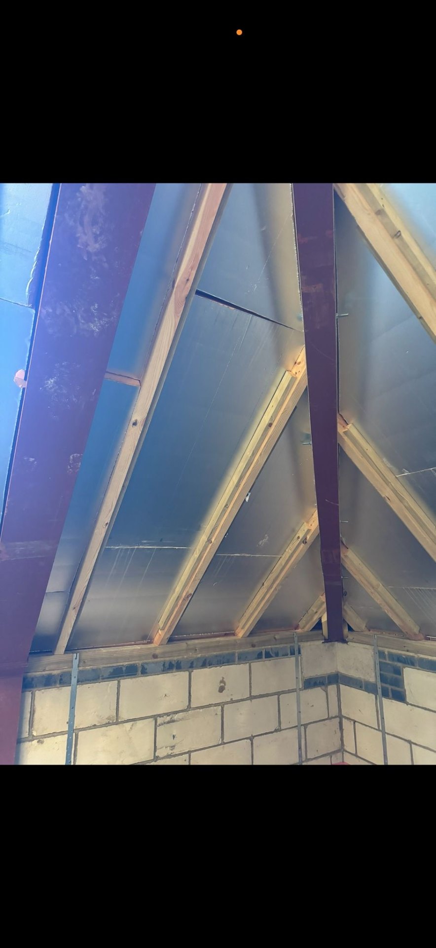 Insulated loft showing foil-backed insulation between timber rafters